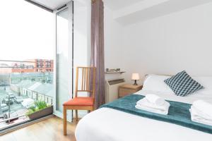 a bedroom with a bed and a large window at Spacious 3-Bed Apt in Dublin Center in Dublin
