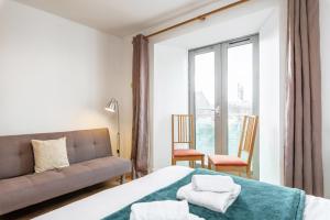 a bedroom with a bed and a couch and a window at Spacious 3-Bed Apt in Dublin Center in Dublin