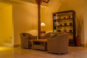 a room with two chairs and a table and a book shelf at Sapodilla Ubud in Ubud