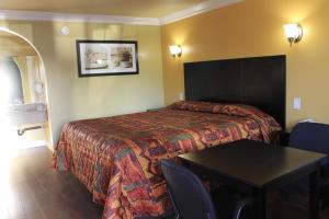 a hotel room with a bed and a table at El Rancho Inn in Hawthorne