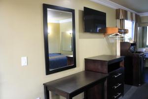 a room with a mirror and a dresser and a bedroom at El Rancho Inn in Hawthorne