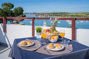 una tavola con piatti di cibo e bicchieri di vino di Ria Guest House ad Alvor