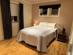 a bedroom with a bed with white sheets and a window at Villa Gratangen in Gratangen