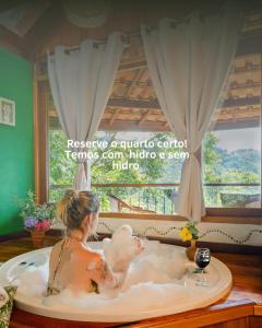 a woman in a bath tub with a chicken in it at Pousada do Rio Maua in Visconde De Maua +36 photos