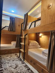 two bunk beds in a room with wooden walls at Hana Stay Hostel in Luxor