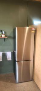 Un refrigerador de acero inoxidable en una cocina. en Hosts on the Coast Estuary Views Studio, en Whangamata