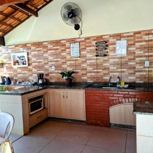 a kitchen with a sink and a fan on the wall at Casa Linear Térrea com Piscina no Atlântico in Rio das Ostras