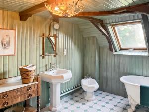 un bagno con lavandino, WC e vasca di Maison Auvergnate à côté de Salers - 4 chambres - parking, garage - jardin - salle de jeux a Drugeac Altre 42 foto