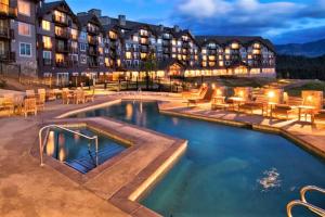 a hotel with a pool in front of a building at 5036 Suncadia Lodge Penthouse with Full Kitchen & Balcony in Cle Elum