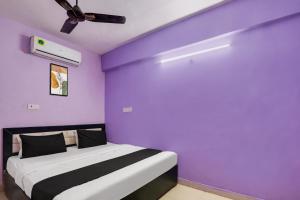 a bedroom with a purple wall with a bed at Hotel O Grand Hotel And Lodge in Hyderabad +27 photos