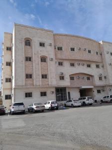 a large building with cars parked in a parking lot at أحد 2 in Al Madinah