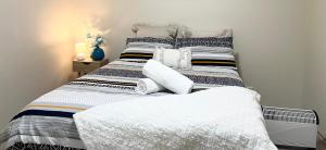 Private Unit underneath a family Home في Cherrybrook: غرفة نوم بها سرير مع ملاءات ووسائد بيضاء