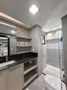 a bathroom with a toilet and a glass shower at O Melhor Flat de Campo Grande in Campo Grande