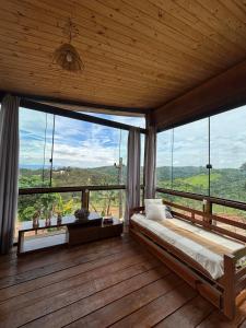 een slaapkamer met grote ramen met uitzicht op de bergen bij Chacara com Chale em Taubate in Taubaté