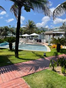 a swimming pool with a palm tree in a yard at In mare 228 in Parnamirim
