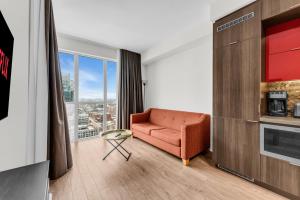 トロントにあるDowntown west Suitesのソファと大きな窓のあるリビングルーム