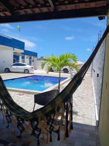 a hammock in front of a swimming pool at Flat Brisa do Mar in Pitimbu