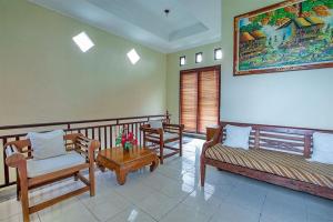 Sala de estar con 2 bancos y mesa en Villa Chandra, en Seminyak
