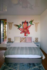 una camera da letto con un grande letto con uccelli sul muro di Hacienda Boutique Santa Rosanna a Santa Rosa de Cabal