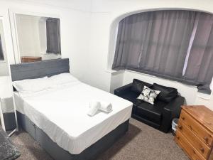 a small bedroom with a bed and a chair at Serene Suite Rooms 1 - 5 in Southampton