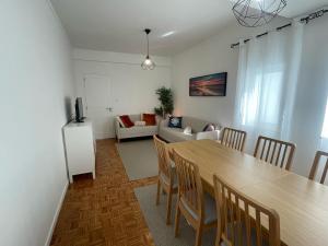 a dining room and living room with a table and chairs at Casa da Baixa in Faro