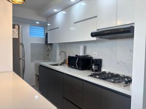 a kitchen with white cabinets and a stove top oven at Apartamento Turistico Monte Azul in Armenia