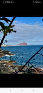 een uitzicht op de oceaan met een eiland in de verte bij Relax flat palm view in San Miguel de Abona