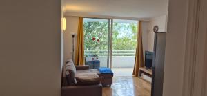 een woonkamer met een bank en een groot raam bij Relax flat palm view in San Miguel de Abona
