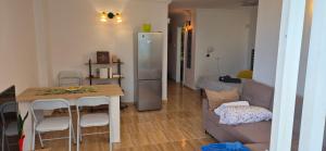 een keuken en een woonkamer met een tafel en een koelkast bij Relax flat palm view in San Miguel de Abona