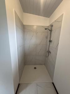 a bathroom with a shower with white tiles at Hava'i Lodge in Taputapuapea +47 photos