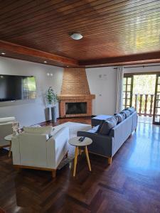 a living room with two couches and a fireplace at Pousada Portal da Serra in Campos do Jordão +226 photos