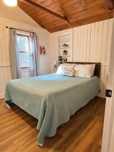 a bedroom with a bed in a room with wooden floors at Lakefront Hot Tub Getaway in Traverse City