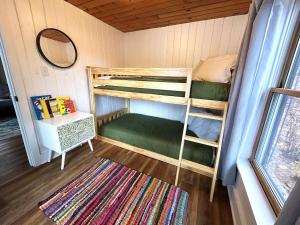 a room with two bunk beds and a mirror at Lakefront Hot Tub Getaway in Traverse City