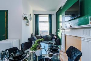 ブラッドフォードにあるChic victorian 2-bed duplex flat - free parkingのリビングルーム(テーブル、椅子、暖炉付)