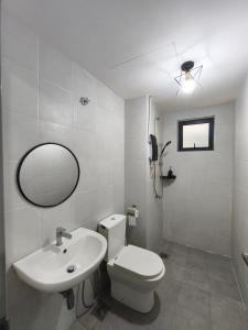 un bagno con un water, un lavandino e uno specchio di Cozy HomeBit a Kuala Lumpur