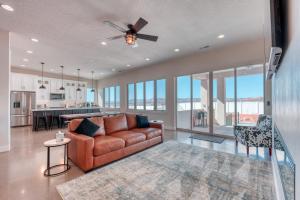 ein Wohnzimmer mit einer Couch und einem Deckenventilator in der Unterkunft Lux Kanab Home with Pool Hot Tub Pickleball Courts in Kanab