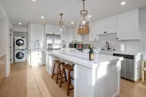 a kitchen with white cabinets and a large island with bar stools at 597 S Sierra Avenue - Unit 68 in Solana Beach