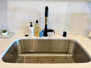 a kitchen sink with a faucet and bottles on a counter at 597 S Sierra Avenue - Unit 68 in Solana Beach