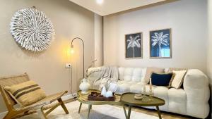 a living room with a white couch and a table at The Cliffs - PradaBeach in Jove