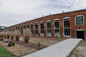 a large brick building with some animals in front of it at Loom Room Retreat in Dalton