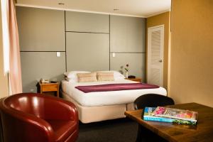 ティマルにあるザ グロブナー ホテルのベッドと椅子とテーブルのある寝室