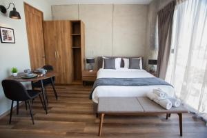 a bedroom with a bed and a table and a desk at Suites del Carmen Consulado in Guadalajara +51 photos