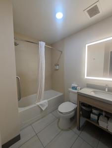 a bathroom with a toilet and a tub and a sink at Candlewood Suites Loveland by IHG in Loveland +75 photos