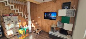a doll house with a staircase and a tv at BUBOVA Chata in Stará Lesná