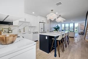 a kitchen with white cabinets and a large island with bar stools at 916 Sea Lane in Encinitas