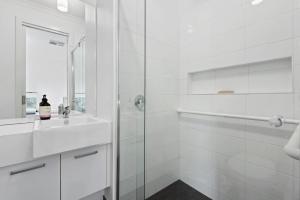 a white bathroom with a shower and a sink at Latte's Nest in Point Lonsdale +7 photos