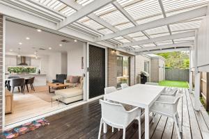 a kitchen and dining room with a white table and chairs at Latte's Nest in Point Lonsdale