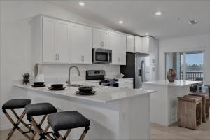 a kitchen with white cabinets and a kitchen island with stools at HLB14224-922 in Burnt Store Marina