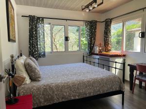 a bedroom with a bed and two windows at Rainbow Iris in Los Naranjos
