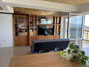 Una sala de estar con una mesa de comedor y un televisor. en Bahia Mágica - 1 dormitorio, en Ushuaia